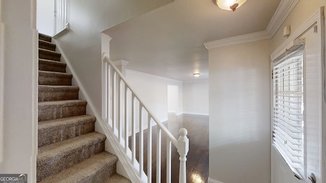 stairway featuring ornamental molding, baseboards, and wood finished floors
