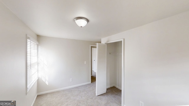 unfurnished bedroom featuring carpet, a closet, and baseboards