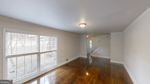 unfurnished room featuring hardwood / wood-style flooring, baseboards, stairway, and crown molding