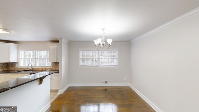 2134 Elinwood Dr, Atlanta, GA 30344 - kitchen with a chandelier, light wood-style flooring, white cabinets, decorative backsplash, and decorative light fixtures