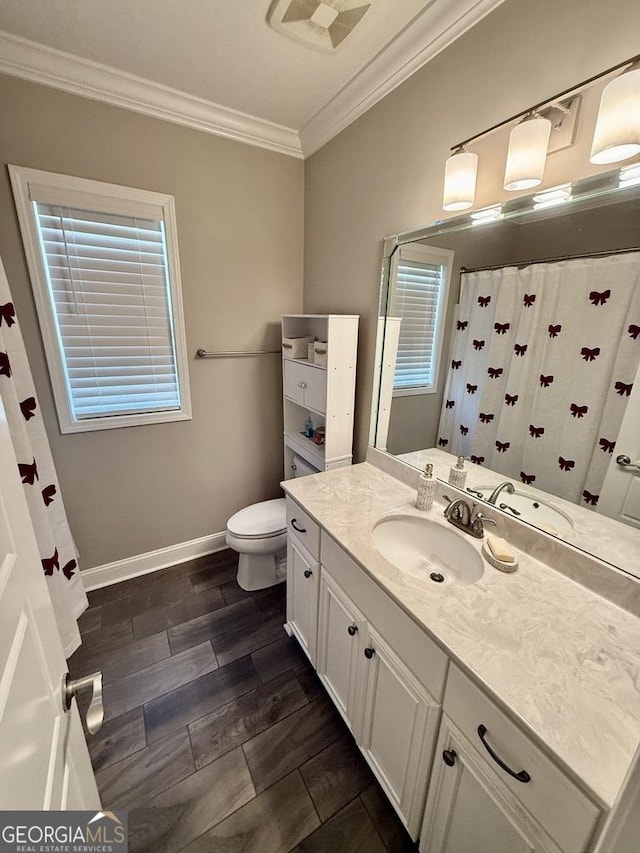 bathroom featuring crown molding, toilet, wood tiled floor, vanity, and baseboards