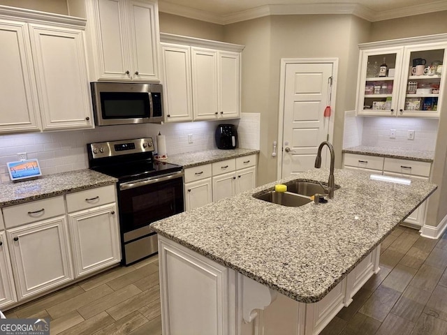 kitchen featuring appliances with stainless steel finishes, wood tiled floor, a sink, and ornamental molding