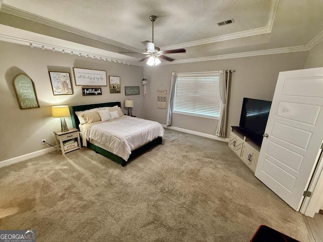 bedroom featuring carpet floors, a raised ceiling, visible vents, and crown molding