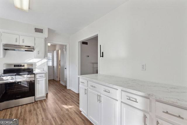 kitchen featuring under cabinet range hood, white cabinetry, visible vents, light wood-type flooring, and stainless steel electric range