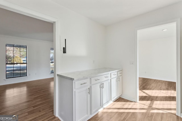 hallway with light wood-type flooring and baseboards