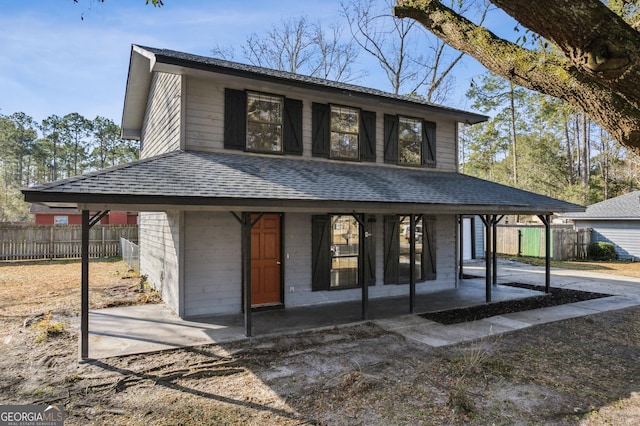 view of front facade featuring fence and roof with shingles