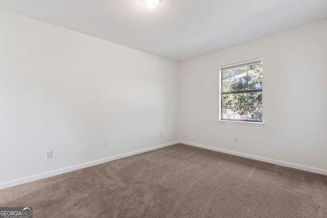 carpeted spare room with baseboards