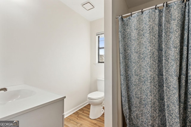 full bathroom featuring baseboards, a shower with shower curtain, toilet, wood finished floors, and a sink