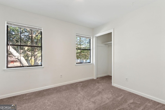 unfurnished bedroom with a closet, carpet, and baseboards