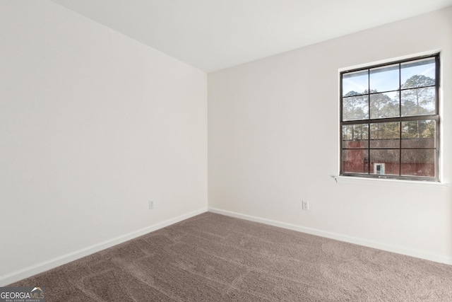 carpeted spare room featuring baseboards