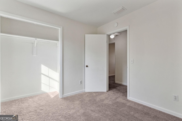 unfurnished bedroom with carpet floors, baseboards, visible vents, and a closet