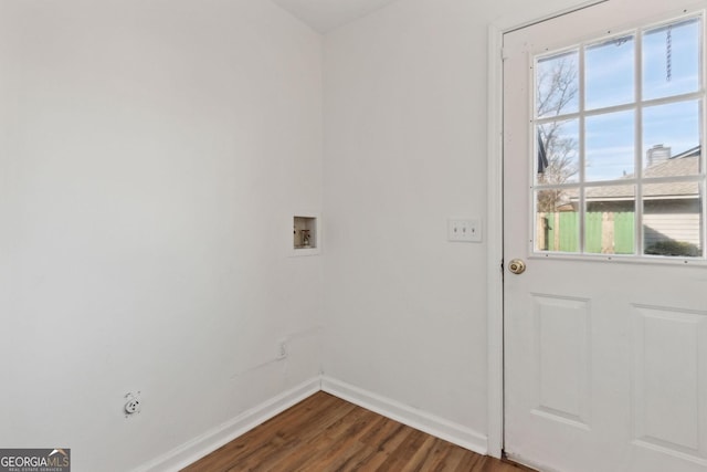 doorway to outside featuring baseboards and dark wood finished floors