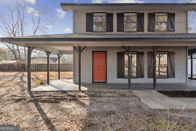 entrance to property featuring fence and roof with shingles