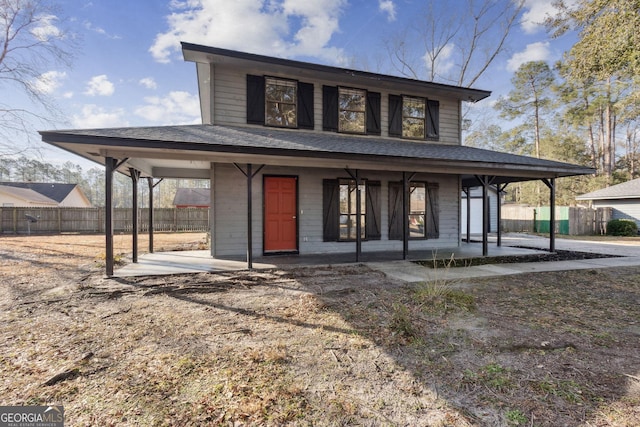 view of front of property with covered porch, roof with shingles, and fence