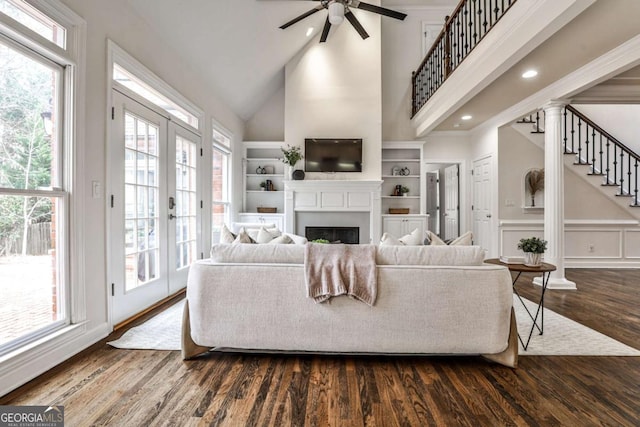 living room featuring plenty of natural light, a fireplace, and dark wood-type flooring