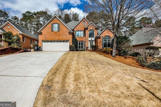 traditional home featuring a garage, driveway, a front yard, and brick siding