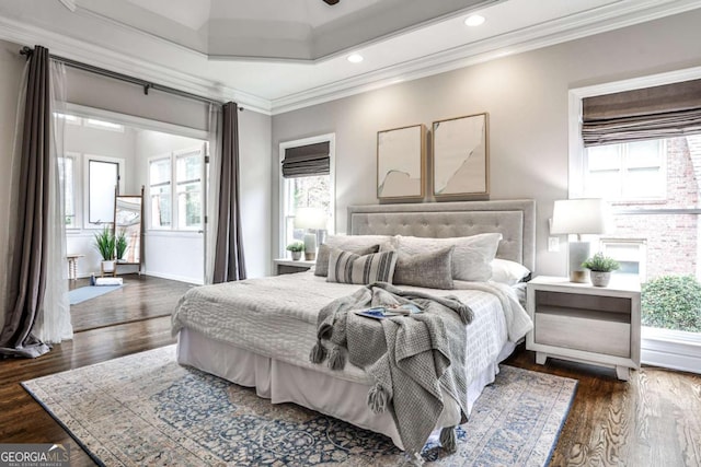 bedroom with crown molding and wood finished floors