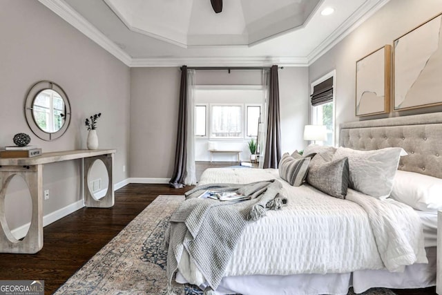 bedroom featuring a raised ceiling, ornamental molding, dark wood finished floors, and baseboards