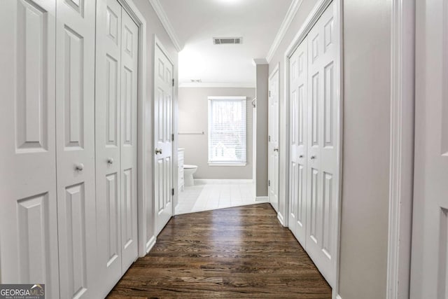 hall featuring ornamental molding, visible vents, and dark wood-type flooring