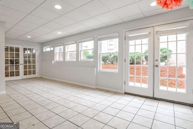 unfurnished sunroom featuring a drop ceiling and french doors