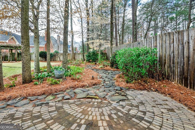 view of community with a fenced backyard and a patio