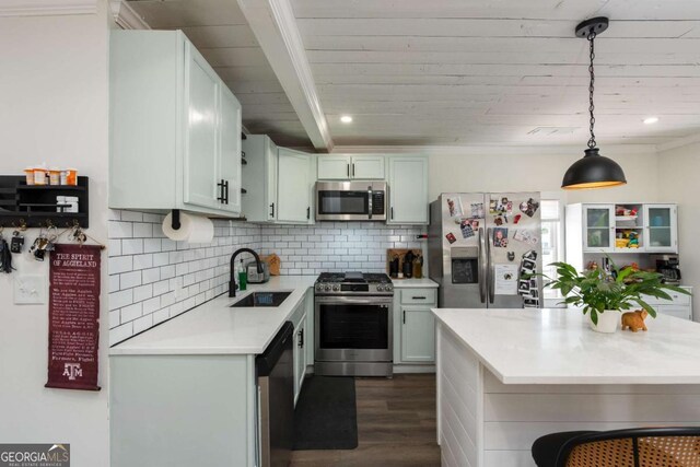 kitchen featuring stainless steel appliances, dark wood-style flooring, a sink, light countertops, and tasteful backsplash