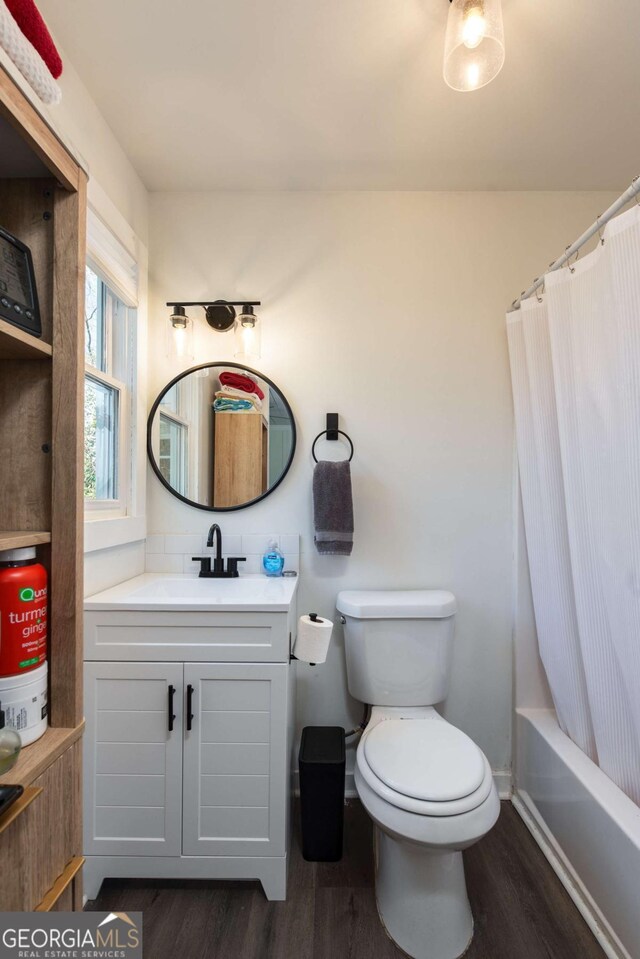 bathroom with baseboards, vanity, toilet, and wood finished floors