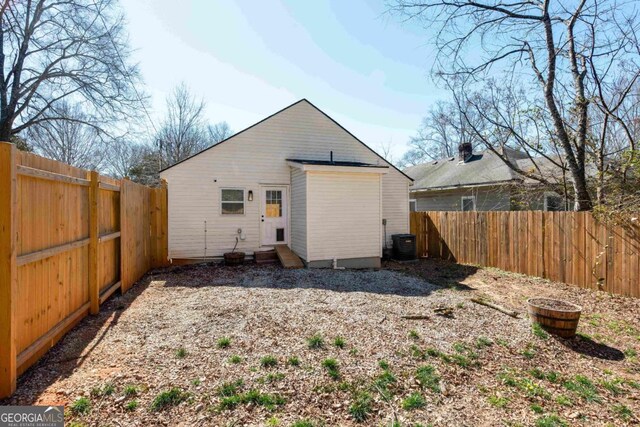 back of house featuring entry steps, central AC unit, and a fenced backyard