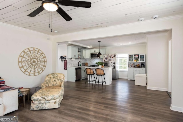 interior space featuring ceiling fan, baseboards, dark wood finished floors, and crown molding