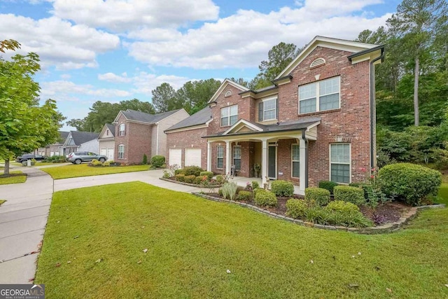 traditional-style house with concrete driveway, brick siding, a front lawn, and an attached garage