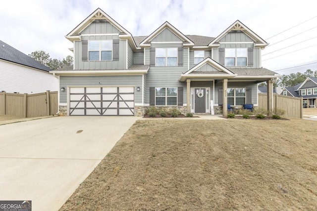 craftsman-style house featuring driveway, a garage, fence, and board and batten siding