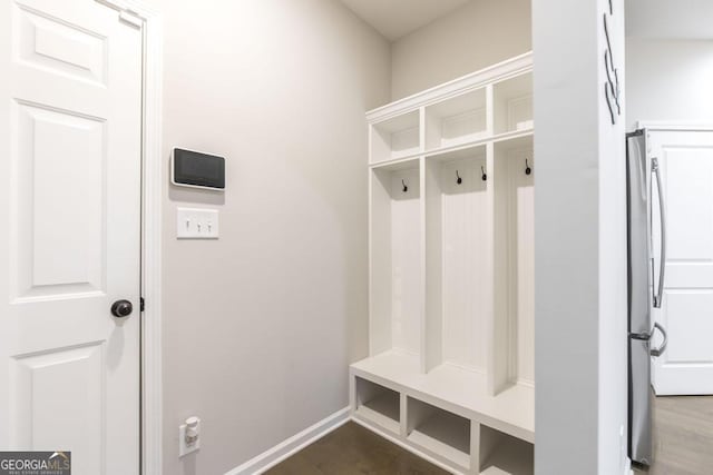 mudroom featuring dark wood-type flooring and baseboards