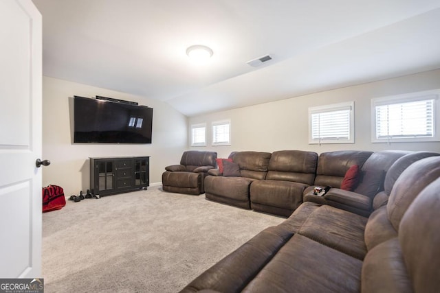 living area with carpet floors, visible vents, and lofted ceiling