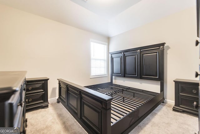 bedroom with baseboards and light colored carpet