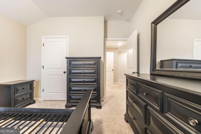 bedroom featuring light carpet, lofted ceiling, and baseboards