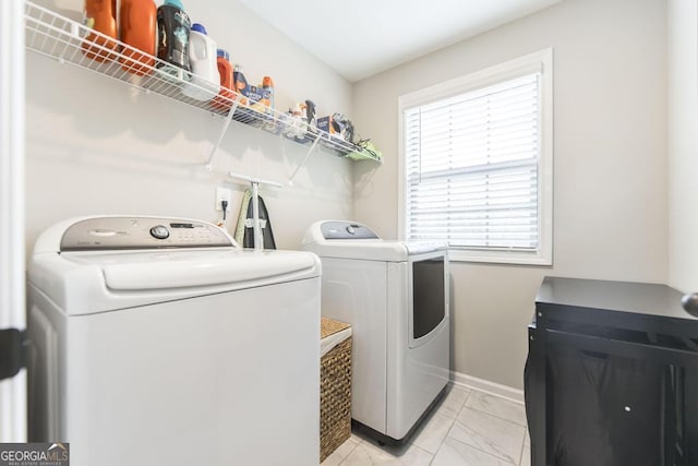 washroom featuring washer and dryer, laundry area, marble finish floor, and baseboards