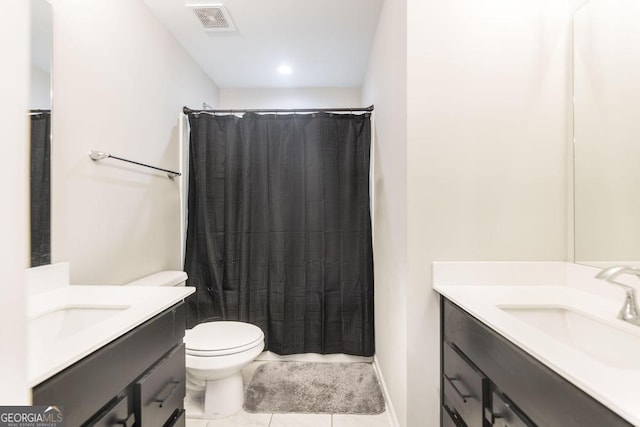 bathroom featuring toilet, two vanities, a sink, and visible vents