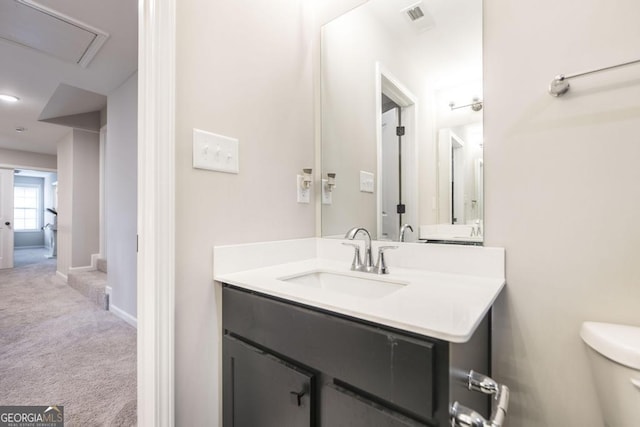 bathroom with toilet, baseboards, visible vents, and vanity