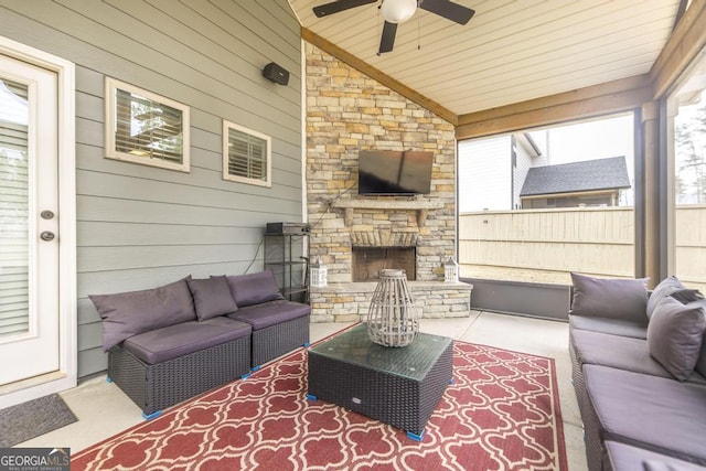 view of patio featuring ceiling fan, an outdoor living space with a fireplace, and fence