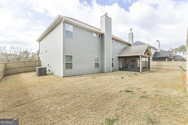 back of house with a yard, central AC unit, a fenced backyard, and a sunroom