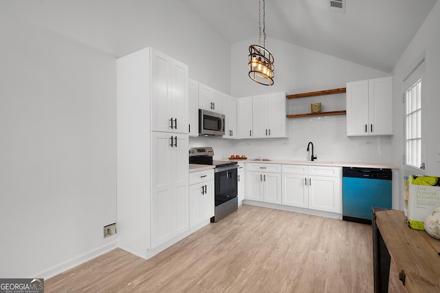 kitchen with appliances with stainless steel finishes, light countertops, light wood-style flooring, and open shelves