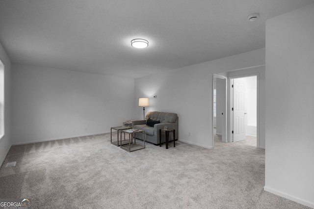 living area featuring visible vents, a textured ceiling, baseboards, and carpet flooring