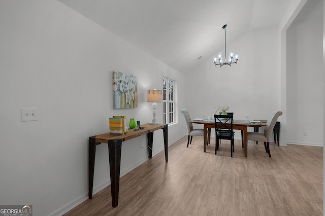 dining room with light wood-type flooring, baseboards, vaulted ceiling, and a notable chandelier