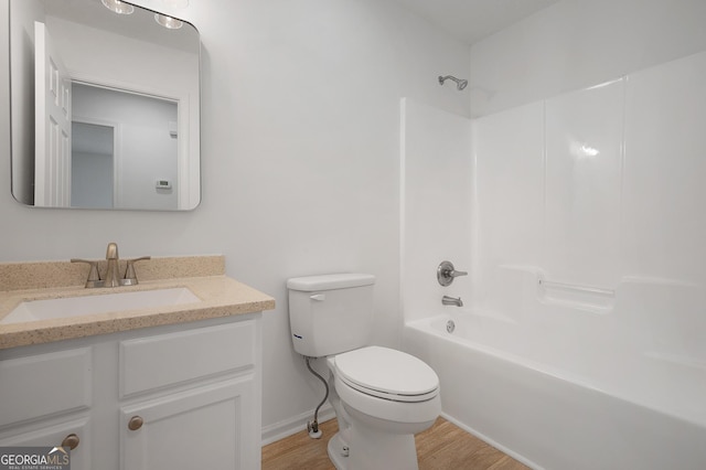 bathroom with shower / bathtub combination, toilet, wood finished floors, vanity, and baseboards