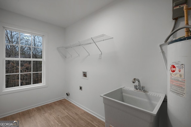 laundry area with hookup for an electric dryer, laundry area, a sink, wood finished floors, and water heater