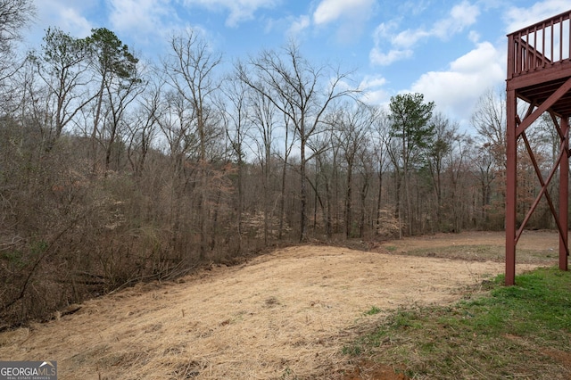 view of yard with a forest view and a deck