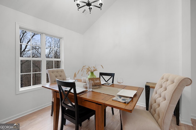 dining space with lofted ceiling, visible vents, light wood-style flooring, and baseboards