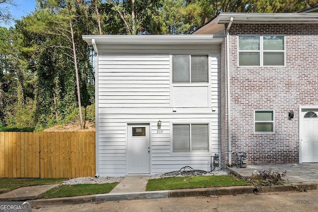 view of front of home with fence and brick siding