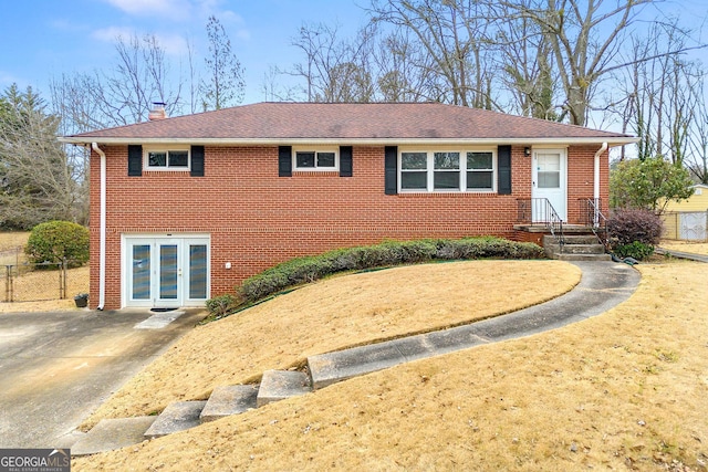 single story home featuring french doors, brick siding, a chimney, and fence