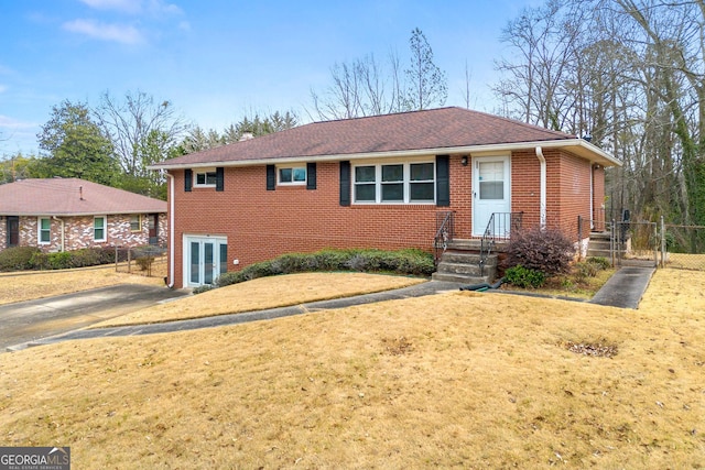 view of front of home featuring brick siding, a front yard, and fence